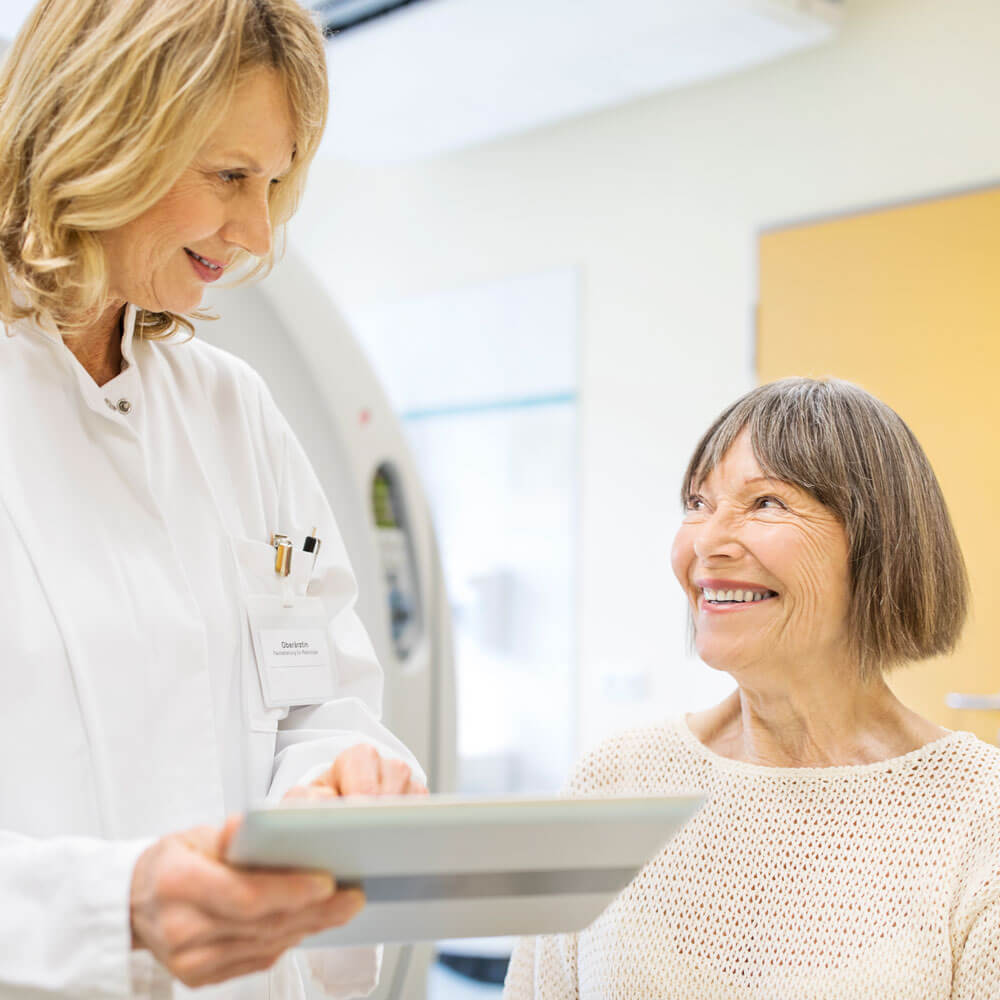 A DEXA scan is a bone density test for osteoporosis. This is a representative image of a female patient speaking with a doctor.